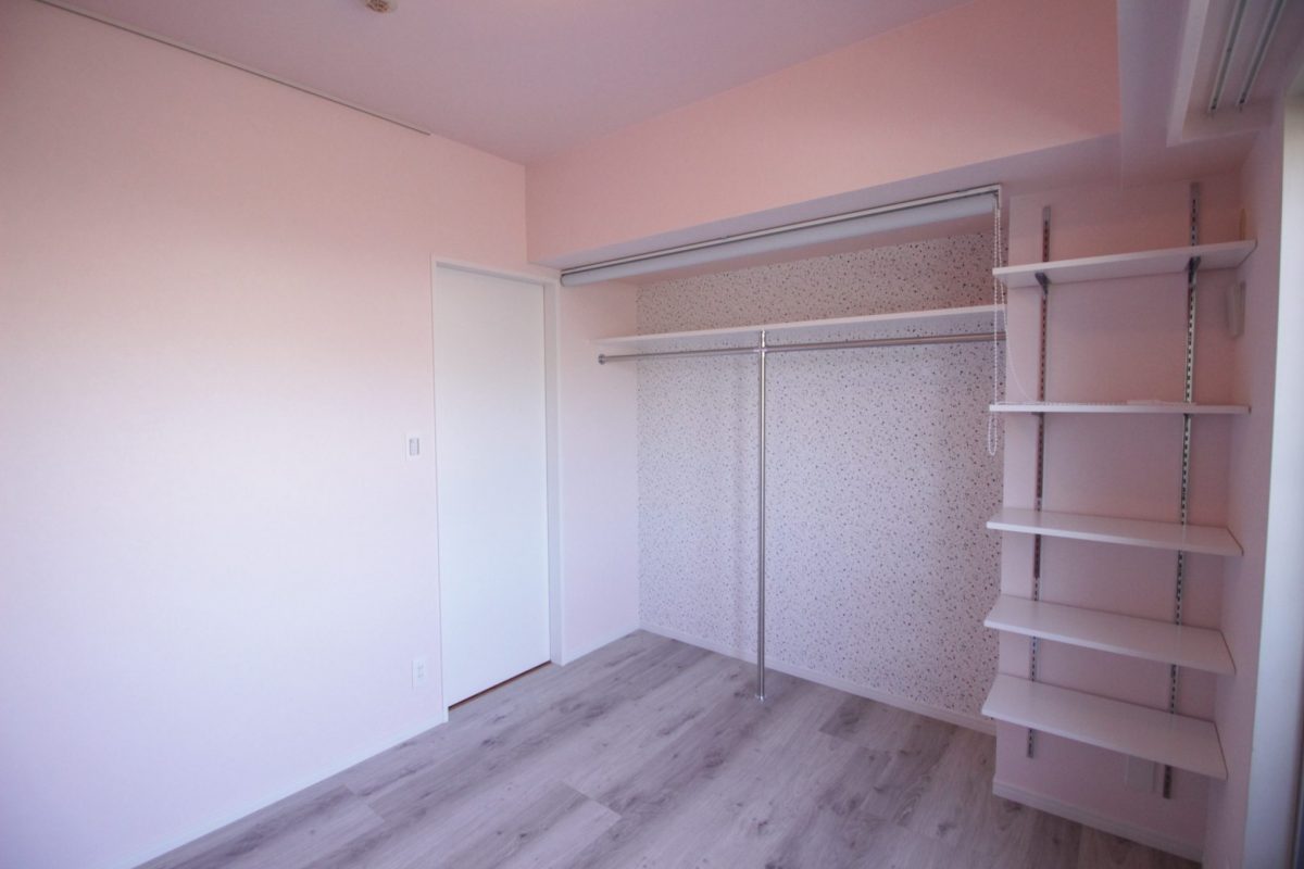 淡いピンクの壁紙と白の室内ドア